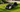 AI robotic lawn mower maintaining a green residential lawn near its charging station