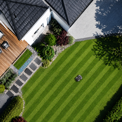 Aerial view of a striped lawn maintained by a robotic lawn mower